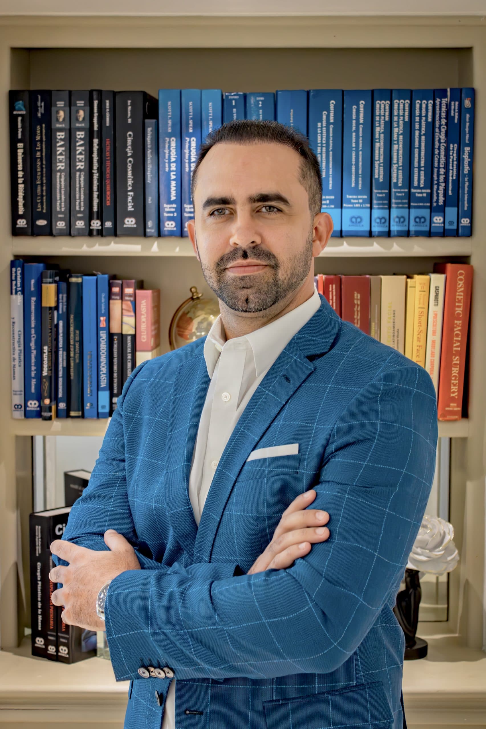 Dr. Jean Paul Giudicelli Saba in a blue suit in front of a medical library