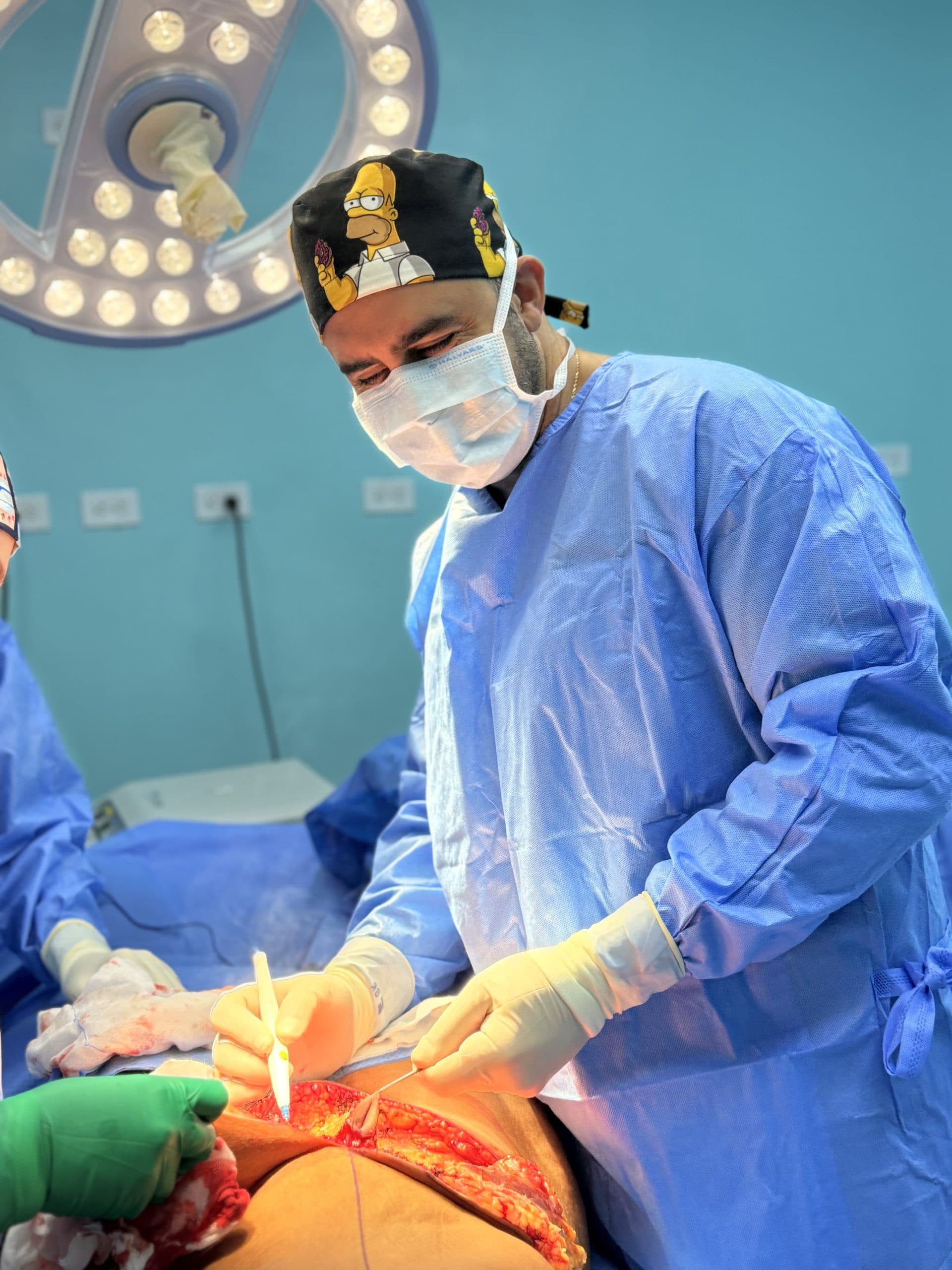Plastic surgeon performing abdominal surgery in the operating room