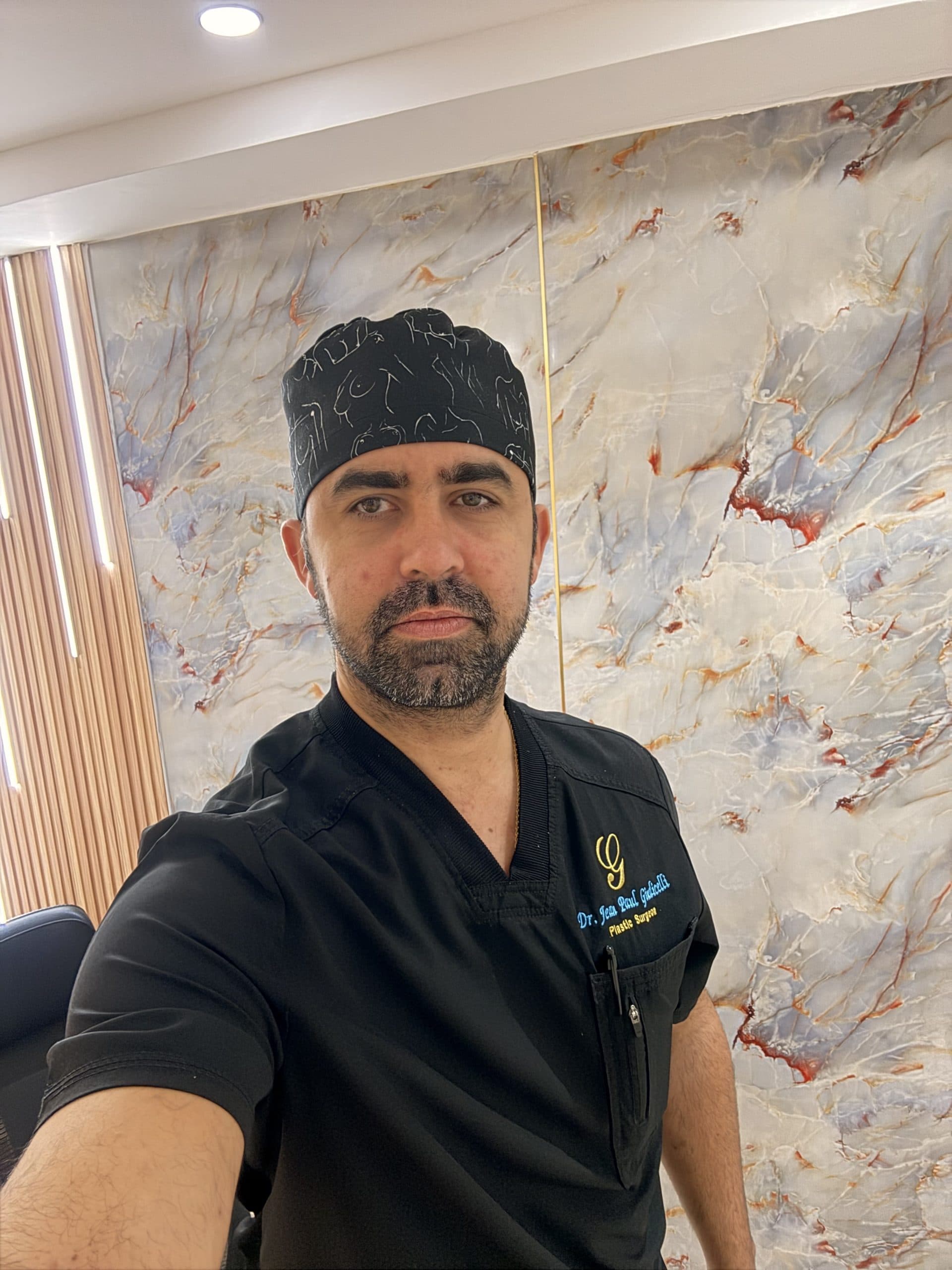 Dr. Jean Paul Giudicelli Saba in black scrubs in his office